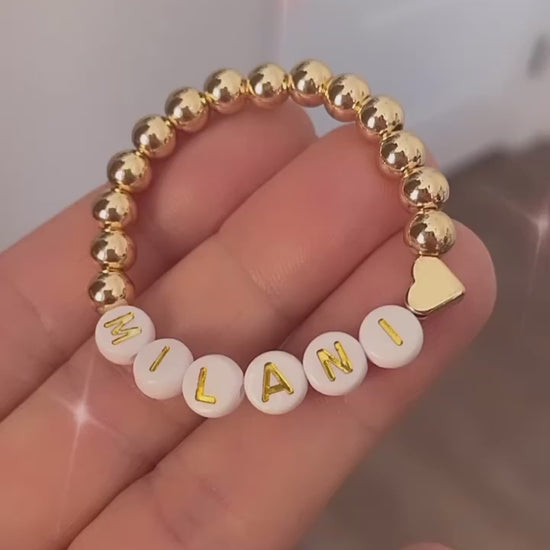 Gold beaded personalized baby bracelet with a heart charm