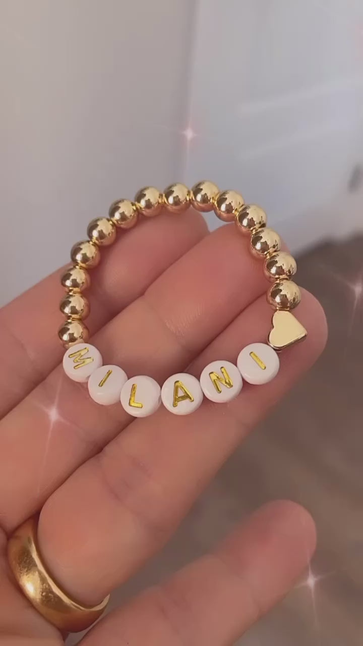 Gold beaded personalized baby bracelet with a heart charm